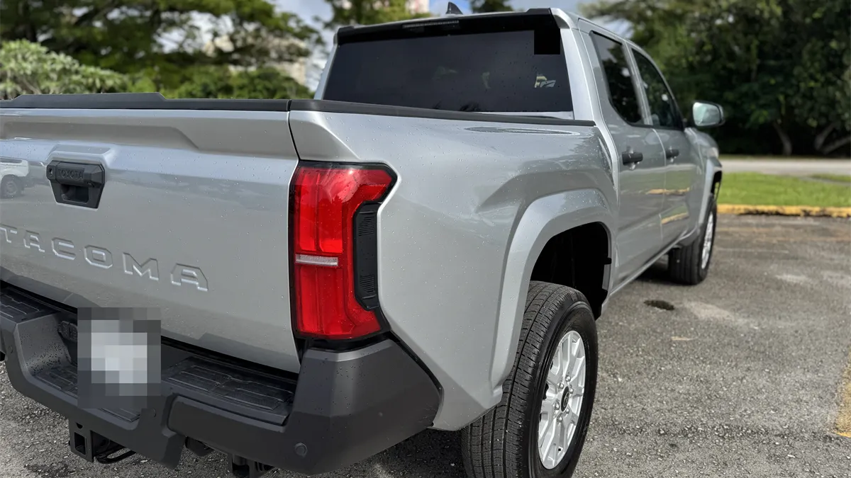 Rear view of a silver Toyota Tacoma pickup truck in a Guam parking lot